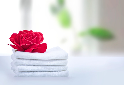 Stack of white towels decorated with rose flower empty copy space.Household.Laundry.