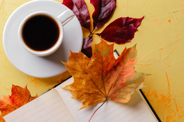 istock Autumn coffee. A cup of espresso, a blank notepad and fall foliage on a yellow concrete table. Flat lay. Close-up 1278799869