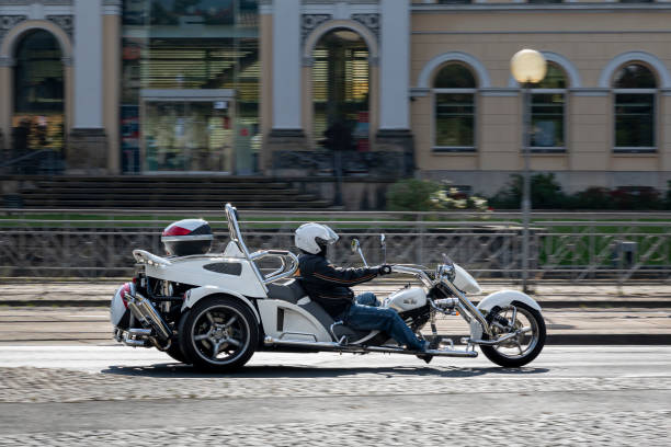A white trike driving on sunny city streets in Braunschweig, Germany. Braunschweig, Germany - oct 3rd 2020: Germany is a promised land of cars but one can see occasionally also bikes or trikes on the streets. braunschweig photos stock pictures, royalty-free photos & images