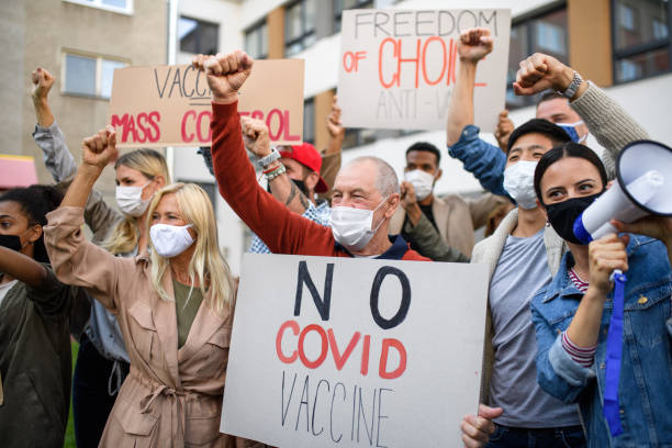 People with placards and posters on public demonstration, no covid vaccine concept. Crowd of people with placards and posters on public demonstration, no covid vaccine concept. protestor photos stock pictures, royalty-free photos & images