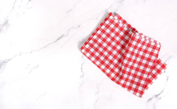 istock Folded red checkered cloth on white table top view.Picnic towel on kitchen table 1278803948