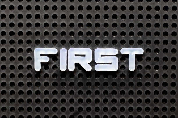 istock White color alphabet with word first on black pegboard background 1278805001