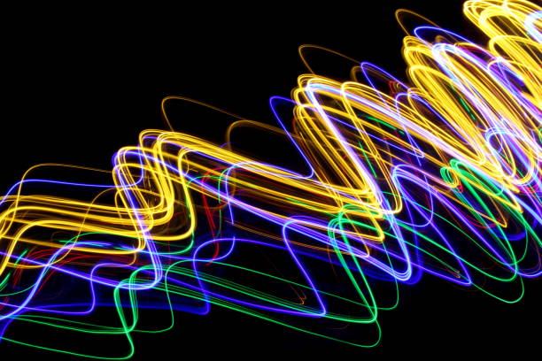 istock Long exposure photograph of neon multi colour in an abstract swirl, parallel lines pattern against a black background. Light painting photography. 1278805501