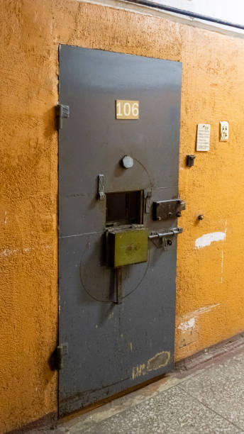 Prison's windows of metal door protect prisoner from inside to escape. Food channel through prison cell's bars. jail, detail of confinement and crime, justice. Prison interior. Concept of limiting freedom. las ventanas de la prisión de la puerta de metal protegen al prisionero del interior para escapar. canal de comida a través de los barrotes de la celda de la prisión. cárcel, detalle del confinamiento y el crimen, justicia. interior de la prisión. con