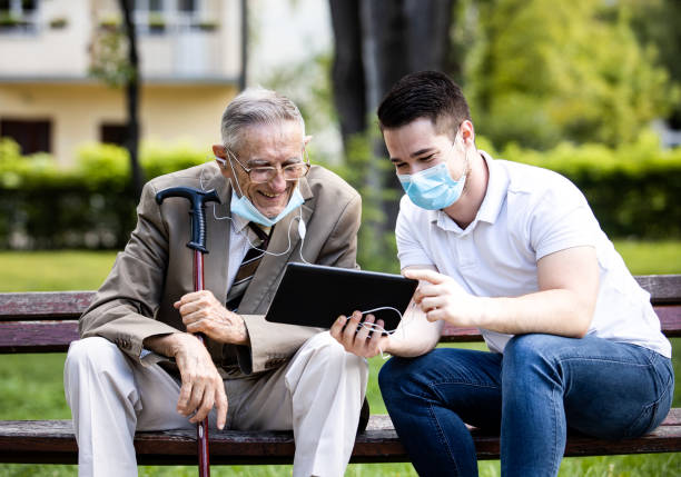 istock Two generations, a grandson and a grandfather, sit on a bench and hawe fun 1278806751