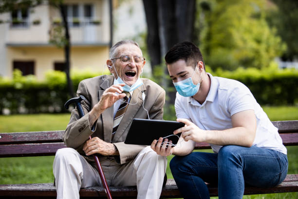 istock Two generations, a grandson and a grandfather, sit on a bench and hawe fun 1278806957