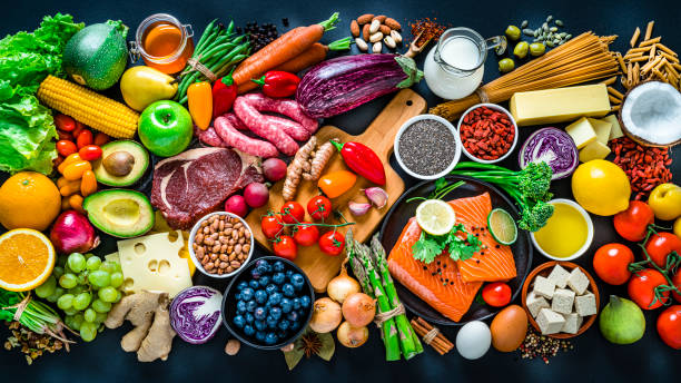 essen und trinken: carbohidrate, protein und ballaststoffe von oben auf dunklem hintergrund geschossen. - vibrant color tomato vegetable pasta stock-fotos und bilder