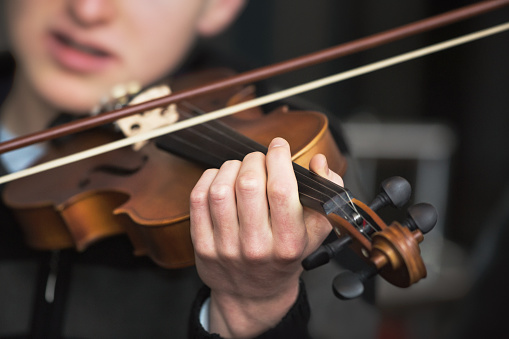 Teenage violin player gets to grips with his instrument, playing classical or country.