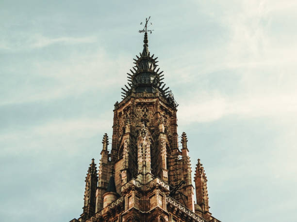 The picture shows a close-up of the top of a church tower located in Toledo, Spain.