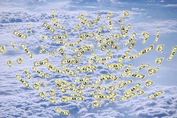 istock Dollar banknotes flying above white clouds in blue sky 1278818623