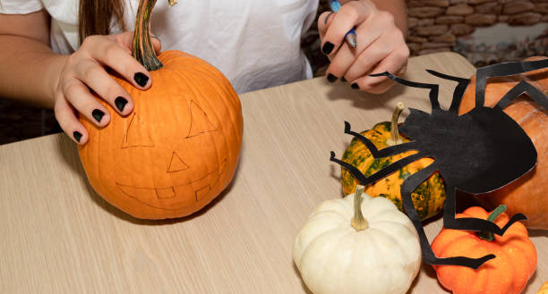 istock On the eve of Halloween, a man drew a face on a fresh pumpkin. 1278819864