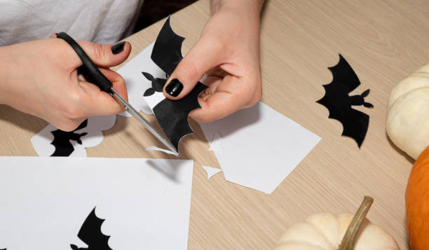 istock A man cuts out paper bats as decorations for a Halloween party. 1278819880
