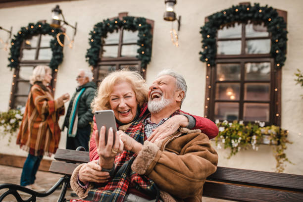 istock Happy senior couple outdoors using phone during winter 1278826200
