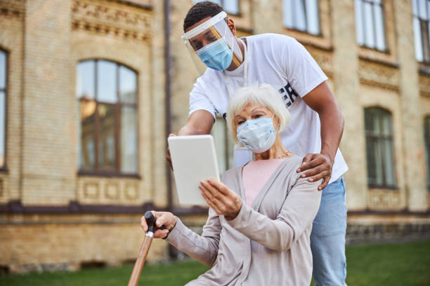 istock Friendly volunteer helping pensioner with making video calls 1278827786