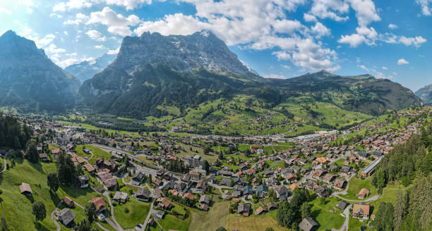 weitwinkel-panoramablick auf die stadt grindelwald und die schweizer alpen - hill grindelwald village landscape stock-fotos und bilder