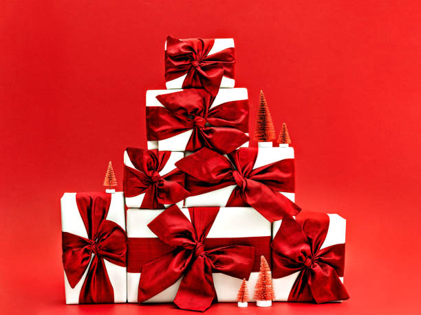 istock Pile of gift boxes and tiny Christmas trees. 1278828411