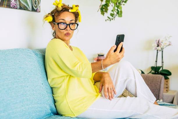 istock Nice pretty caucasian woman at home doing video conference or crazy nice expression at the phone to take picture to share online - yellow and blue colors with white background 1278829290