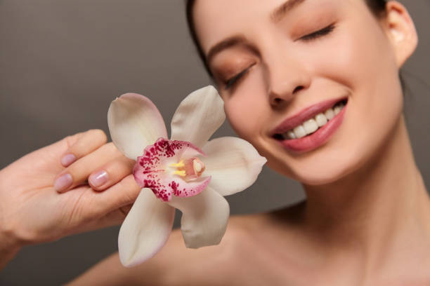 istock A smiling young white lady with an orchid flower. 1278829338