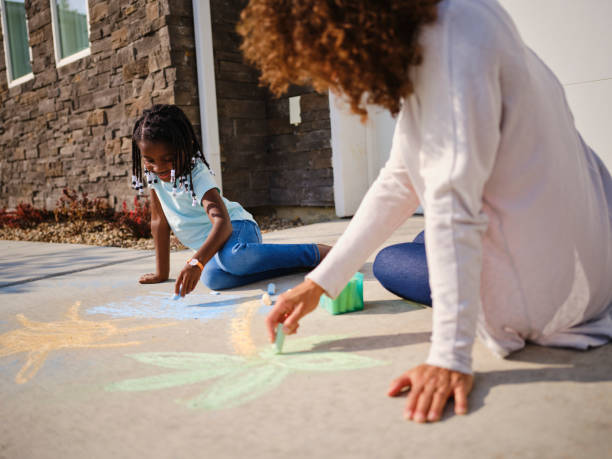 madre e hija recordando unas vacaciones - little girls sidewalk child chalk fotografías e imágenes de stock