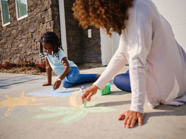 madre e figlia ricordando una vacanza - little girls sidewalk child chalk foto e immagini stock