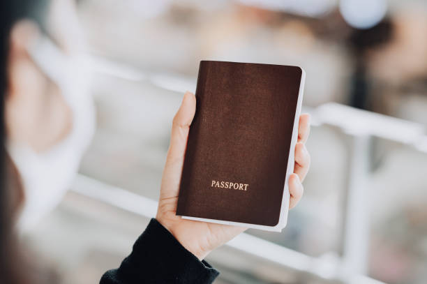 istock woman wearing mask holding passport 1278830636