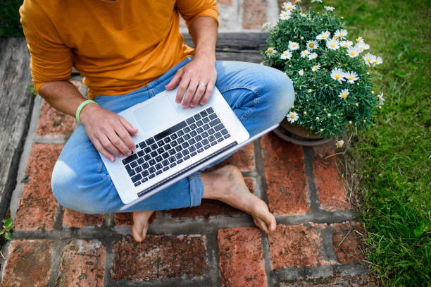 istock Unrecognizable man with laptop working outdoors in garden, home office concept. 1278831888
