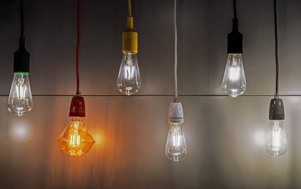 istock Light bulbs with multi-colored electric cords on a dark background. 1278833532
