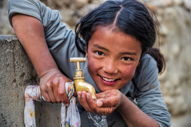 непальская девочка пьет воду, верхний мустанг, непал - lo стоковые фото и изображения