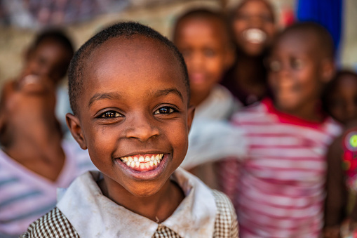 Close up portrait of a Cute Little African Kid with a Big Beautiful Smile Looking at the Camera. Happy Male Child in a Rural Area Representing Innocence, Peace and Hope. Documentary Footage