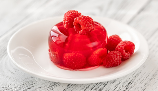 Portion of raspberry gelatin dessert on white plate