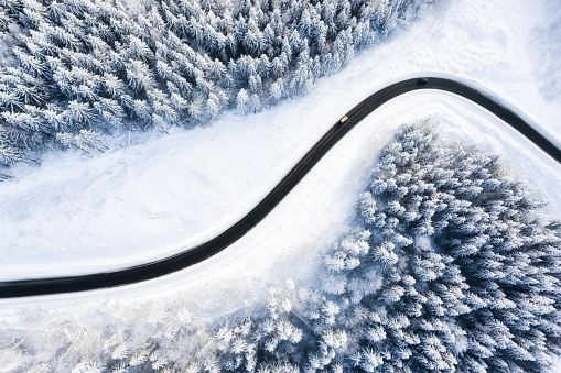 Winter chill. Natural winter landscape from air. Aerial view on the road and forest at the winter time. Forest and snow.