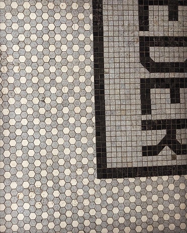 Close up of hexagonal tile floor with letters showing