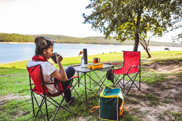 frau trinkt kaffee - campingplatz stock-fotos und bilder