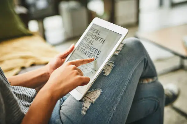 Closeup shot of an unrecognisable woman using a digital tablet at home