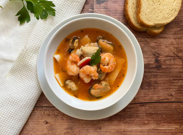 italienische fischsuppe mit verschiedenen meeresfrüchten, garnelen, garnelen, calamari, muscheln und muscheln. serviert mit weißbrot. - mediterranean cuisine mediterranean culture food bread stock-fotos und bilder