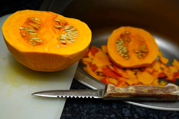peeled and cut hokkaido pumpkin in the kitchen while cooking stock photo