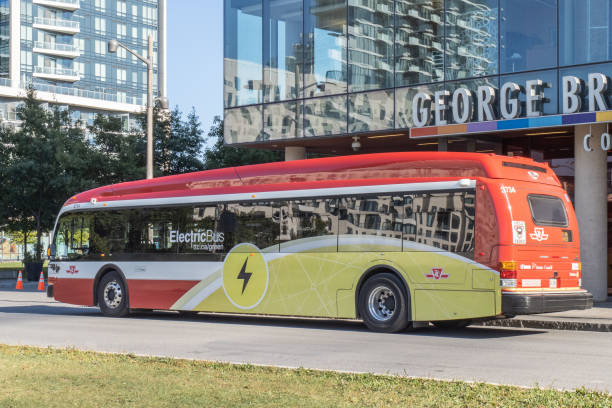 An electric bus  under way at the waterfront campus of George Brown College in Toronto as part of an environmental project Toronto Canada; A Toronto Transit Commission TTC Proterra electric bus at a bus stop on Queens Quay by the waterfront in summer. sustainable energy toronto stock pictures, royalty-free photos & images