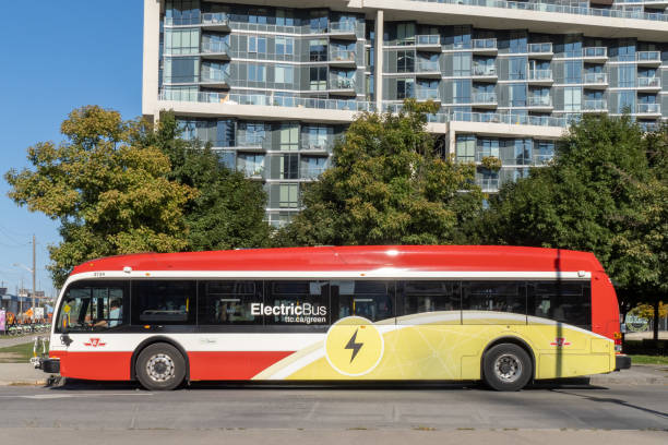 An electric bus  under way in Toronto as part of an environmental project Toronto Canada; A Toronto Transit Commission TTC Proterra electric bus at a bus stop on Queens Quay by the waterfront in summer. sustainable energy toronto stock pictures, royalty-free photos & images