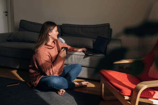 istock Smiling Woman Using her Laptop PC at Home on a Winter Morning 1278843063