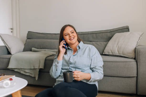 istock Happy Curvy Woman Makes a Phone Call on her Mobile Phone 1278843111