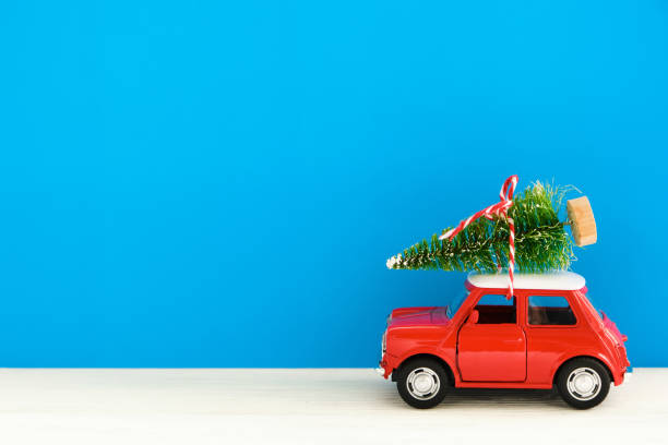 istock Little red toy car and Christmas tree on a blue background 1278848482