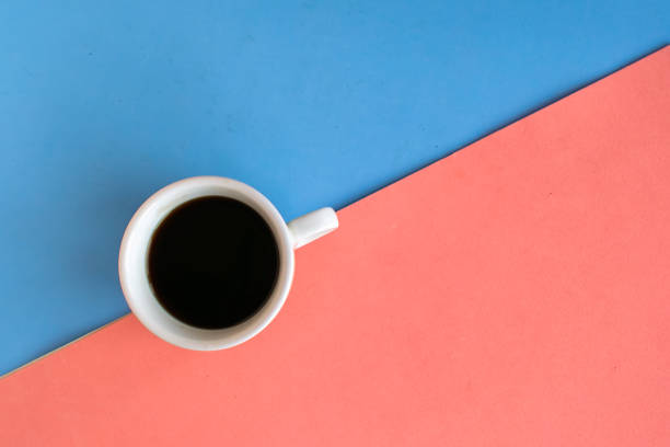 istock Coffee cup on geometric blue and pink background, top view, copy space for the text, minimal concept 1278851239