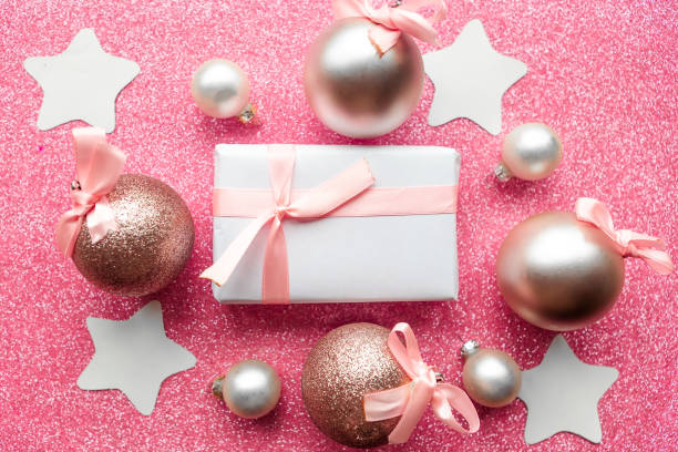 istock Christmas baubles and gift box on pink glitter background, copy space for the text. Merry Christmas greeting card 1278855436