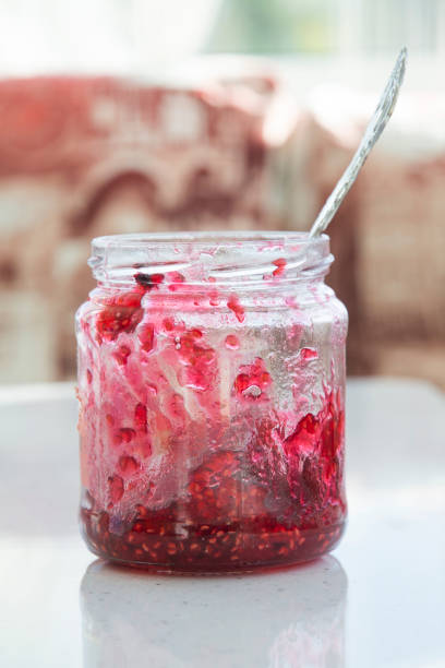 istock madine jam in a jar with a spoon, jar half empty, tea with raspberry jam, flu prevention. 1278856309