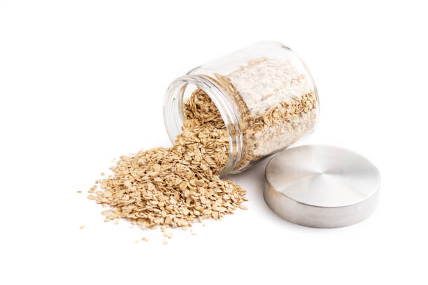 istock Side view of fallen oat flakes from a jar isolated on white background 1278857383