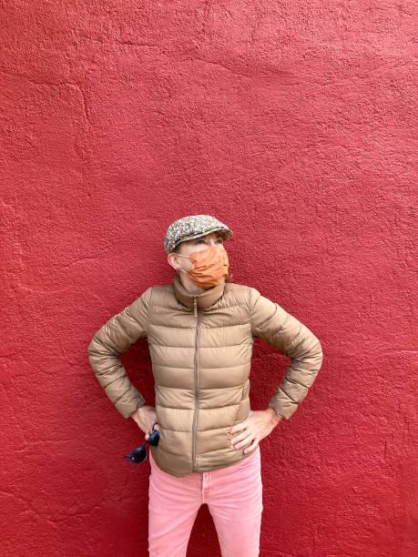 istock Woman Wearing Orange Mask, Red Background 1278857629