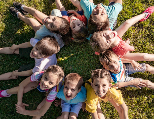 istock Cheerful kids sitting on the grass 1278857743
