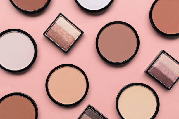 istock Cosmetic products for makeup on pastel pink background. Beige eyeshadow, blush and face compact powder for different skin colors concept. Trendy beauty pattern. Top view. Flat lay. Closeup. Tone cream 1278858464