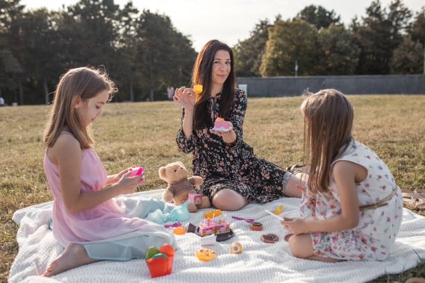 istock Mother and daughters having a tea party in park 1278869744
