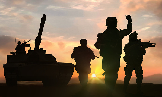 Soldiers and tank on battlefield during sunset